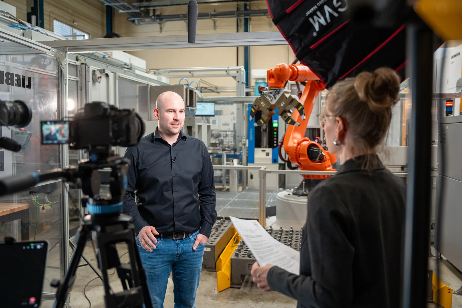 Interview-Setup für ein Testimonialvideo: ein Mitarbeiter gibt vor laufender Kamera ein Statement